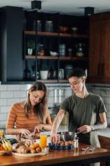 Fototapeta premium Lesbian couple preparing breakfast together in modern kitchen