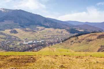 Naklejka premium carpathian countryside scenery with fields on the hills and village in the valley. natural environment. mountainous rural landscape of ukraine on a sunny day in spring. borzhava ridge