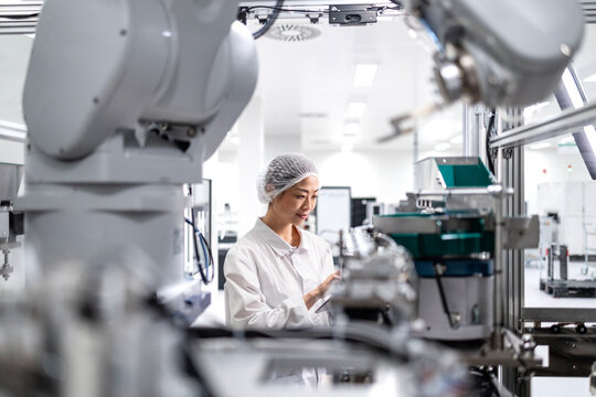Japanese factory worker controlling production process of electronics equipment in automobile industry.