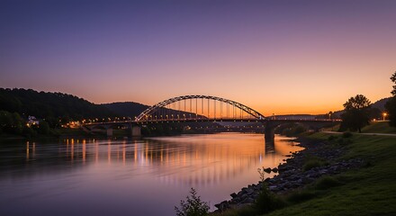 Fototapeta premium Stunning bridge over calm river at sunset. Mountains and landscape. Peaceful cityscape.