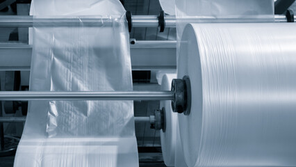 Automatic polyethylene plastic bag production machine with lighting effect. Close-up of the roller...