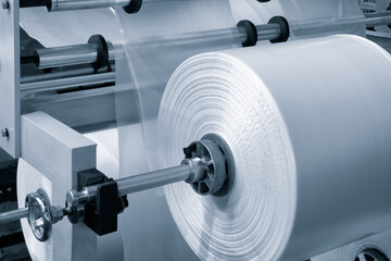 Automatic polyethylene plastic bag production machine with lighting effect. Close-up of the roller...