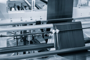 Fragment of the conveyor of sticking labeling machine. Abstract industrial background.