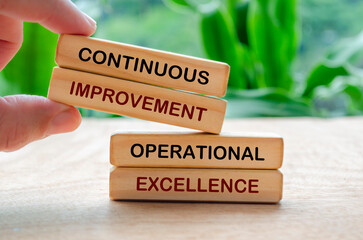 Continuous improvement and operational excellence text on wooden blocks. Business strategy and...