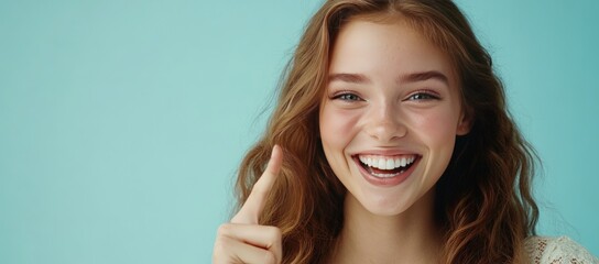 Naklejka premium A woman with curly hair is joyfully smiling and pointing at her face