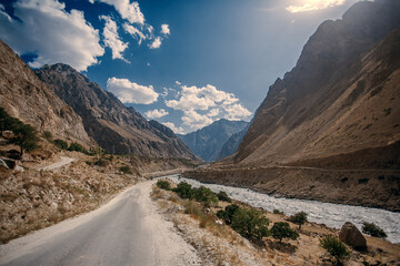 A road winds through a desert with mountains in the background