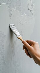 diy wall painting with hand and brush focusing on intricate details of gray strokes