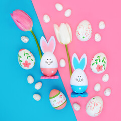Easter eggs tulip flowers and cute bunny background on pink blue background. Seasonal fun design for greeting card.