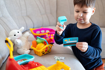 A child plays store with a toy cash register.