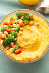 Creamy hummus topped with chickpeas, broccoli, and bell peppers.