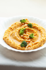 Creamy hummus with chickpeas and broccoli florets, a delicious and healthy meal.