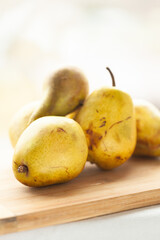 Ripe yellow pears on a wooden cutting board.  Ready for cooking or snacking!
