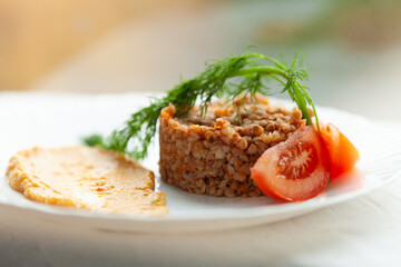 Buckwheat dish with tomato and creamy sauce garnish. A healthy and delicious meal.