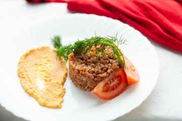 A delicious and healthy buckwheat dish, served with a side of creamy puree and fresh tomato slices.  Garnished with dill for a fresh touch.