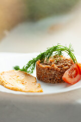 Delicious buckwheat groats with a side of hummus and tomato slices, garnished with fresh dill. A healthy and appetizing meal.