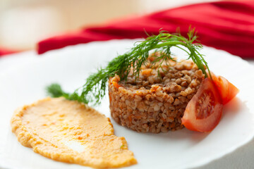 Delicious buckwheat groats with a side of creamy puree and fresh tomato slices.  Garnished with dill.
