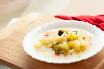 Creamy vegetable soup in a white bowl, served on a wooden board.  Perfect for a light and healthy meal.
