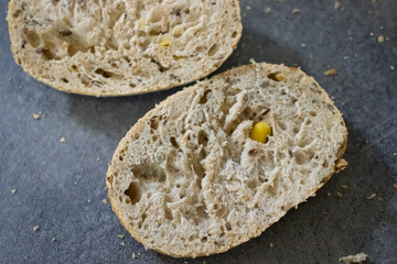 Freshly baked bread sliced open, revealing a soft texture and scattered grains, perfect for showcasing culinary delights.