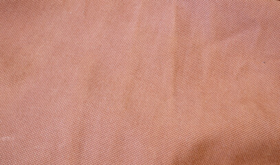 Fototapeta premium Soft, textured fabric in warm peach color, ideal for backgrounds, fashion shoots, or product photography. Perfect for adding warmth and depth to visuals.