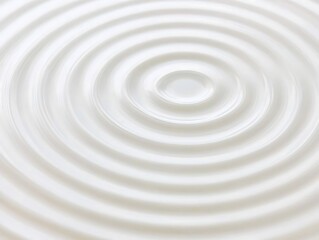 A close-up shot of water ripples in circular patterns, the fine details of the waves visible against the white backdrop, giving a sense of calm and balance