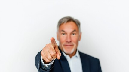 Confident businessman pointing at camera in office environment