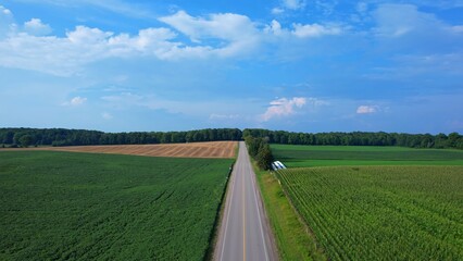 Aerial view of agricultural farms and crops fields. Agricultural landscapes from above depicting vibrancy of farms in Canadian soil. Planted corn and soy. Planting rows of crops during sun set.