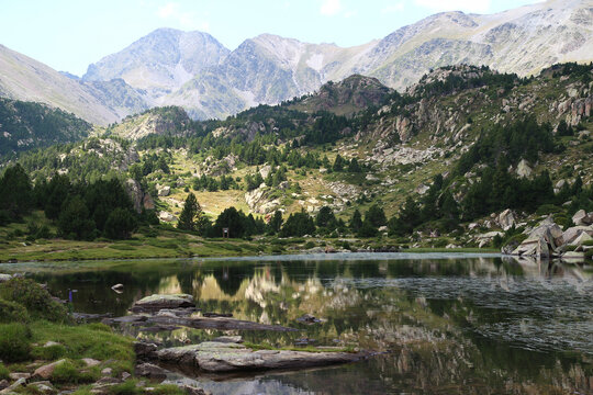 With the Pic Carlit above, the rocky banks of the Bailleul lake are reflected in its clear waters on an August afternoon (Pyr&eacute;n&eacute;es Orientales, France)