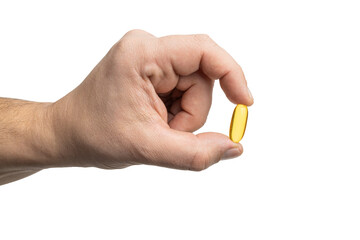 Male hand holding yellow omega-3 capsule, fatty acid, fish oil supplements, close-up view, isolated on transparent background