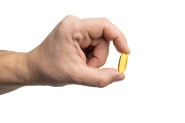 Male hand holding yellow omega-3 capsule, fatty acid, fish oil supplements, close-up view, isolated on transparent background