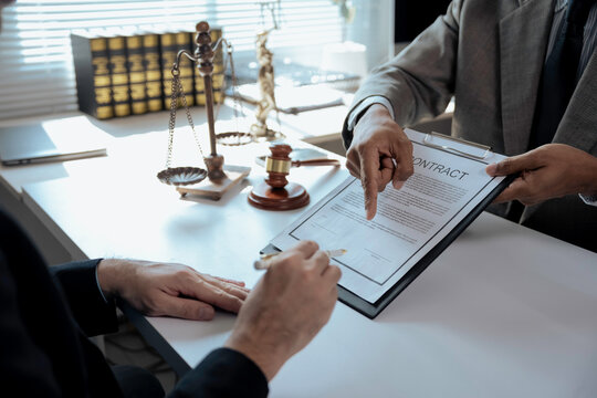 Lawyer showing contract details and explaining where to sign
