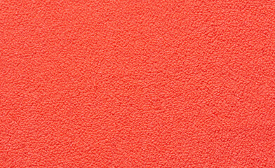 Bright red textured carpet close up with soft fiber pattern and detailed abstract design.