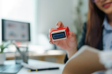 Businesswoman stamping document in office with approved stamp