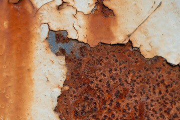 Rust and old, falling paint on the iron bridge structure.
