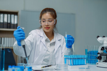 Scientist using micropipette and test tube working in modern laboratory