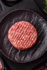 Fresh raw ground beef burger patty with salt and spices