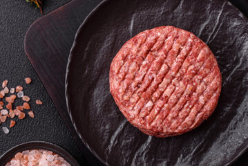 Fresh raw ground beef burger patty with salt and spices