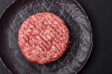 Fresh raw ground beef burger patty with salt and spices