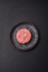 Fresh raw ground beef burger patty with salt and spices