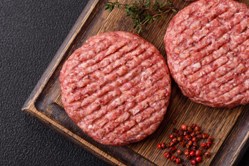 Fresh raw ground beef burger patty with salt and spices