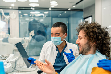 Caucasian Male Consults with Female Dentist in Clinic