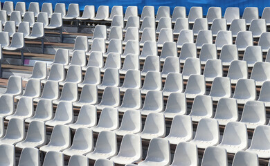 Empty white stadium seats. Outdoor plastic spectator chairs