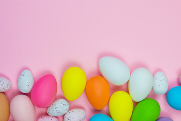 Easter pink background with bright colored eggs and space for text