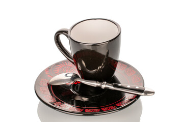 Black ceramic cup with saucer, close-up, isolated on white background.