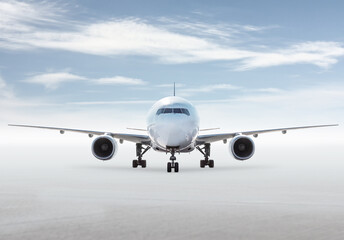 Front view of wide body passenger plane isolated on bright background with sky
