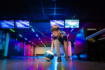 happy young boy child have fun cheering while playing bowling game bowling alley