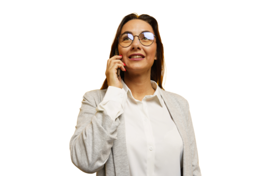 Confident woman talking on the phone while standing against a white background in a professional outfit
