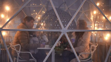 Enjoy an intimate and cozy winter dining experience inside a beautifully illuminated glass igloo that shines