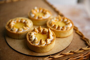 Group delicious Lemon Tartlets on a wood plate, wooden background