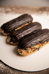 Chocolate eclair with a custard cream filling on a white plate