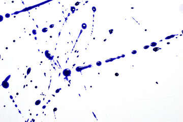 Drops of blue watercolor paint are randomly applied onto a white background.